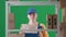 In the frame on a green background a limp. Depicts a young woman in a uniform. Depicts an employee, in a warehouse. She