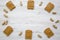 Frame made of peanut butter toasts and unshelled peanuts on a white wooden background, top view.