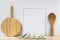 Frame mockup, wood cutting board, spoon, olive tree branch on white background, styled image