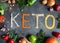 Frame of organic products: lentils, oatmeal, beans, millet on a dark gray background. Keto word made from ketogenic food. Keto,