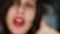 Frame is out of focus. Beautiful blurred girl with a short haircut and red lipstick on her lips makes a sloppy haircut