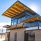 Frame Park building with flat roof and brick wall under blue sky and bright sun