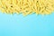 Frame from penne type of pasta on cheerful blue background with empty space for text