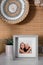 Frame with photo of elderly woman and her granddaughter on white table indoors