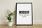 Frame, poster mock up with vertical black frame and plant. Empty frame standing on the wooden floor. Free space for your