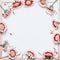 Frame of pretty red white flowers on blank white chalkboard background, top view.