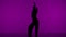 In the frame on the purple background in the silhouette. Dances slender, beautiful girl. Demonstrates dance moves in the