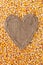 Frame in the shape of heart made of burlap with corn