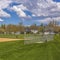 Frame Square Baseball or softball field with buildings and trees beyond the grassy terrain