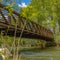 Frame Square Bridge with metal guardrails over the glistening water at Ogden River Parkway