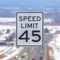 Frame Square Close up of a Speed Limit sign at a highway surrounded with snow in winter