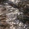 Frame Square Close up of a stream with translucent frozen water over dark rocks