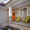 Frame Square Facade of home with bright orange front door decorated with a festive wreath