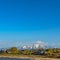 Frame Square Lake with grassy shore and glittering water against mountain and blue sky