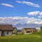 Frame Square Pathway on a vast grassy terrain leading to the houses in front of a lake