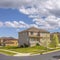 Frame Square Paved road along lovely homes under blue sky with puffy clouds on a sunny day