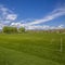 Frame Square Vast sports field with soccer goal net and baseball bleachers behind a fence