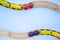 Frame for text made of multicolor kids train cars bricks on wooden railway on blue background. Copyspase. top view. flat lay.