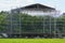 frame of an unfinished metallic gray scene from twigs stands on green grass in the park