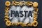 Frame of variety italian pasta on black stone background