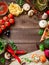 Frame with vegetables, pizza, sushi rolls, tomato, pasta, olives and sauce on wooden background. Food concept for menu. Flat lay.