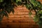 Framed Christmas template, place for text. Brown wooden background with unfocused fir branches and warm golden garland lights