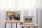 Framed family portraits near window in room