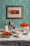 Framed orange and cinnamon pound cake on a wall, table set for coffee