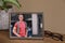 Framed photo of happy young man near houseplant and glasses on wooden table