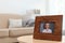 Framed portrait of senior woman on table indoors