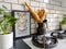 Framed taxidermy butterflies art in a black and white subway tiled kitchen with numerous plants