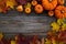 Framework with pumpkins and fall leaves on wooden background. Top view.