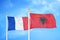 France and Albania  two flags on flagpoles and blue cloudy sky