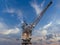 France Caen January 25 2020. Old gantry crane standing at the canal wharf in the harbor used for unloading. Blue sky at sunset