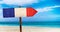 France flag on wooden table sign on beach background. It is summer sign of France