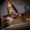 FRANCE, GIRONDE, SAINT-EMILION, SAMPLING A GLASS OF WINE IN A BARREL WITH A PIPETTE FOR TASTING AND VINIFICATION