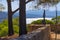 France, Saint-Tropez, Citadel. View through a few trees and shrubs on the Citadel, the water of the bay or Saint-Tropez, and the m