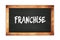 FRANCHISE text written on wooden frame school blackboard