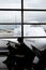 FRANKFURT, GERMANY - JULY 21: Silhouette of passenger waiting for flight in terminal with Lufthansa jumbo jet in perspective in t