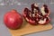 Frash pomegranate on a wooden desk, pomegranates in the background