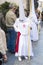 A fraternity member adjusting their tunic accompanying Palm Sunday procession