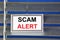 Fraud alert - text message in the banner sign on the hunting hook.