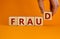 Fraud symbol. Concept word fraud on wooden cubes