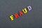 FRAUD word on black board background composed from colorful abc alphabet block wooden letters, copy space for ad text