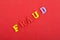 FRAUD word on red background composed from colorful abc alphabet block wooden letters, copy space for ad text. Learning