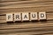 FRAUD word written on wooden cubes. Finance Concept. Money