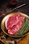 Freah Raw cap rump beef meat steak in a plate with thyme, top sirloin steak. Dark background. Top view