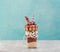 Freakshake with donuts on gray wooden background