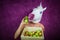 Freaky young woman in comical mask stands on the purple background