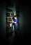 Freckled red-haired little boy searching book on bookcase